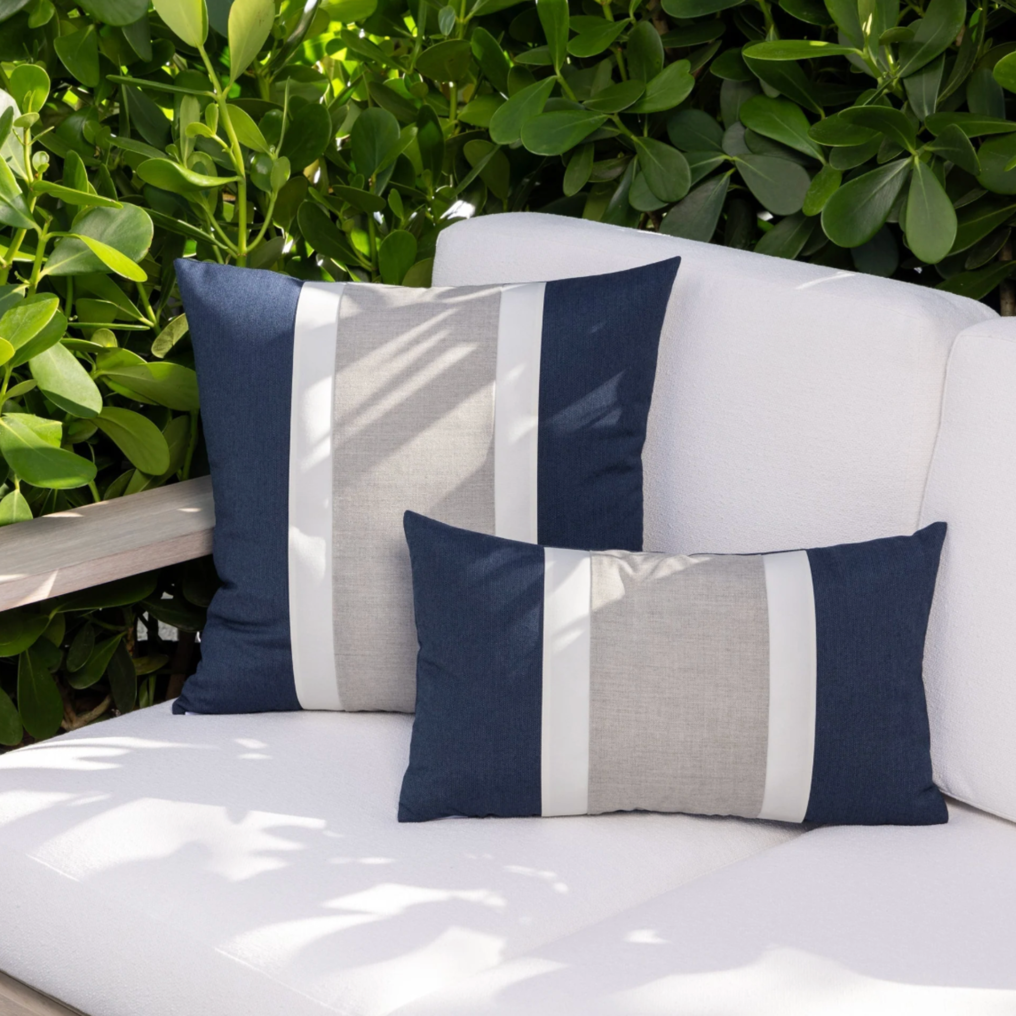 anna maria island indigo and white color block throw pillow layered on neutral sofa in coastal living room lifestyle