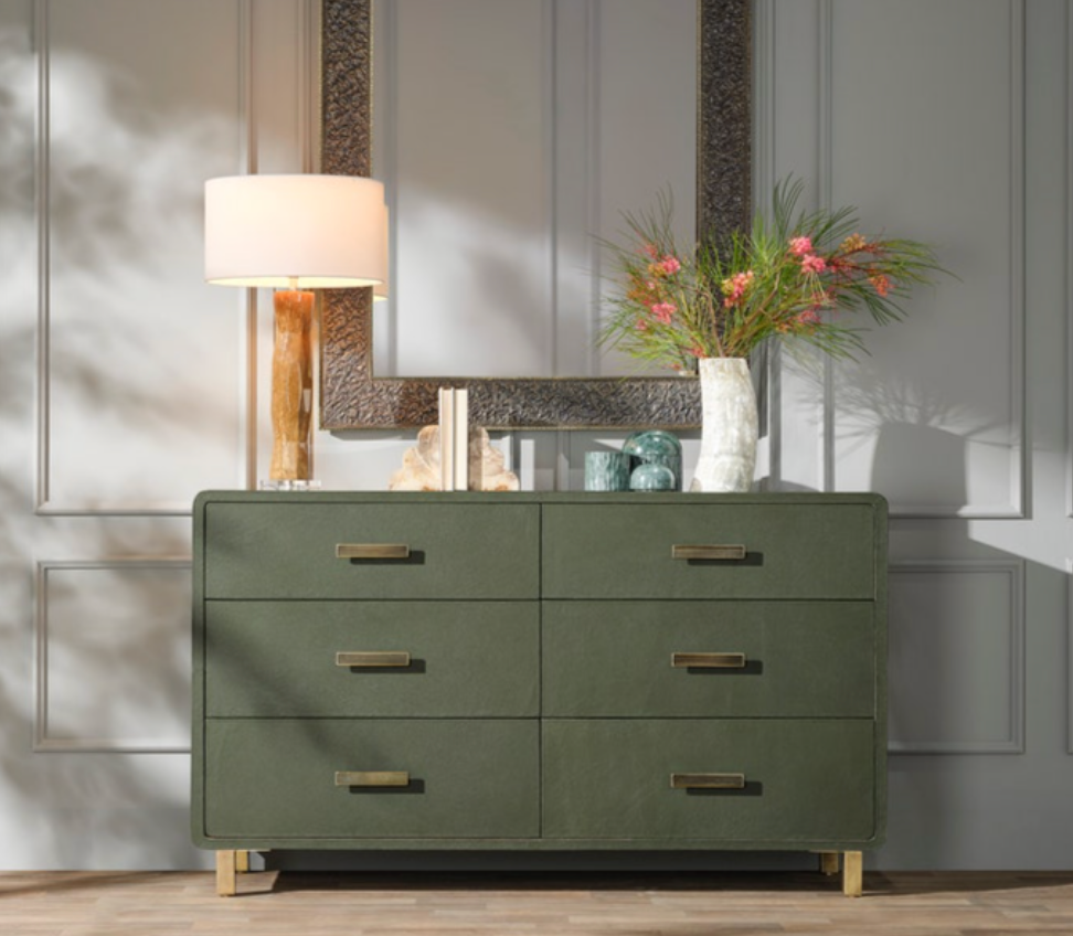 Green dresser with gold handles in a room setting with a lamp and mirror Our Boat House