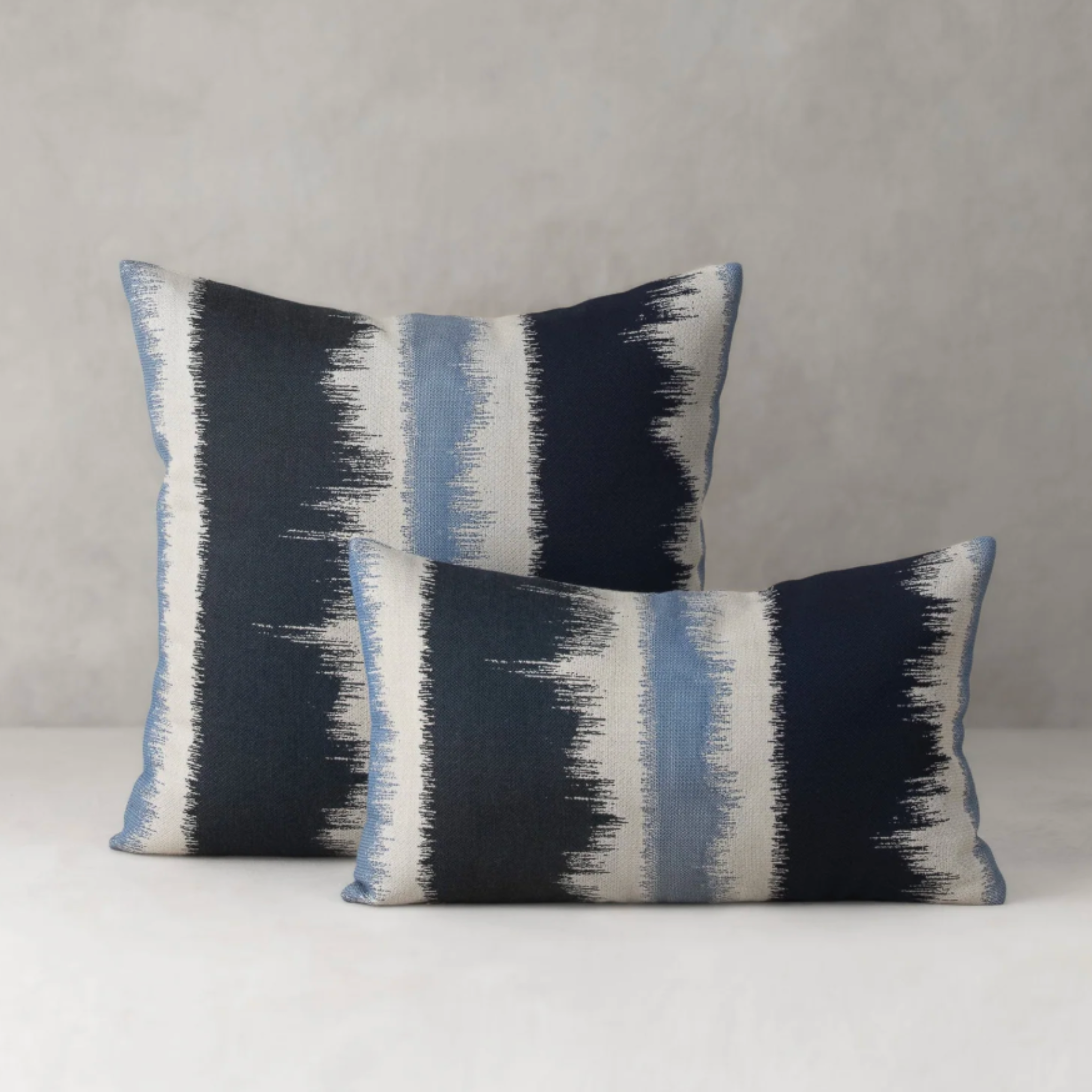 miramar blue and white throw pillow styled on neutral sofa in coastal living room lifestyle