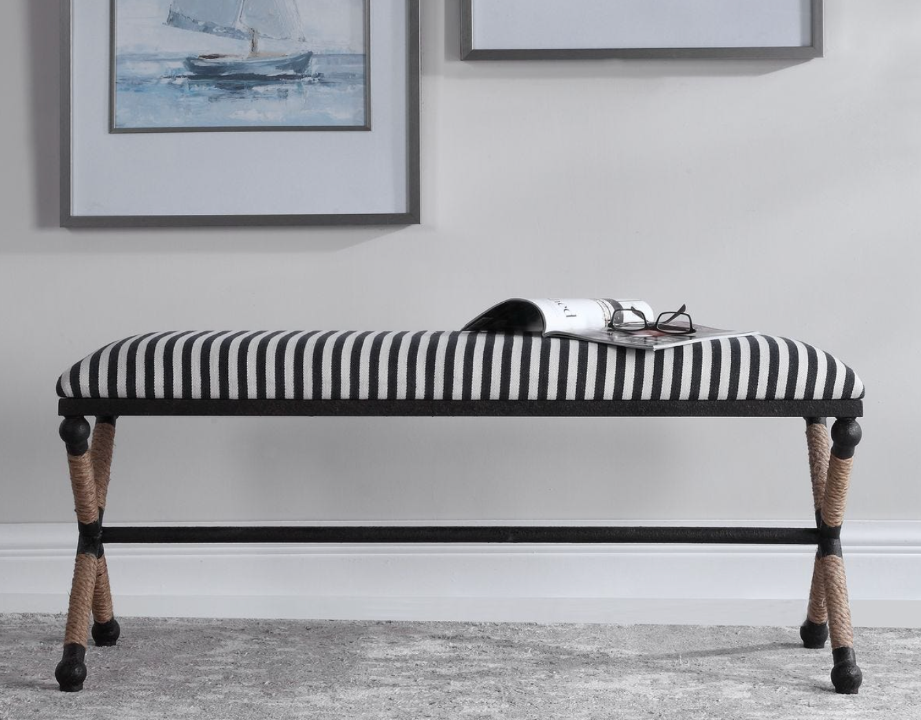 Striped bench with decorative legs in a room with framed pictures on the wall. Our Boat House